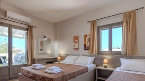 A hotel room with a large bed, a smaller bed, a desk with a lamp, a chair, and a window with curtains. - Aloe,pool,near beach & amenities no car needed (Adelianos Kampos)