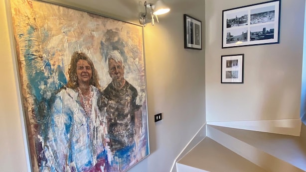 A staircase with a patterned carpet leading up to a landing where a large abstract painting and two framed photographs are displayed. - Villa in the Green in the hills in Lavagna - 3 Bedrooms, Garden and Private Parking (Lavagna)