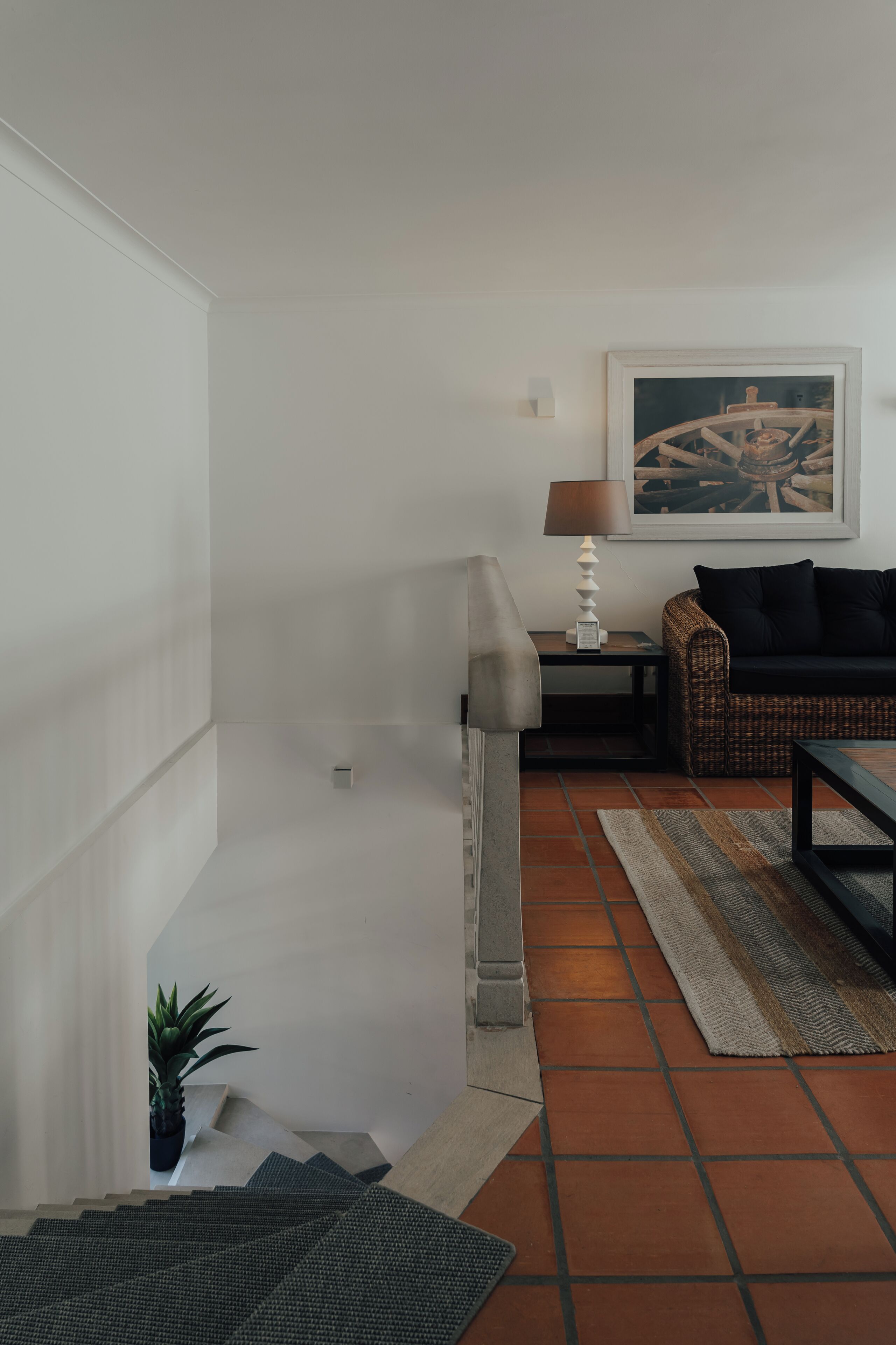 A modern living room with a sofa, a lamp, and a painting on the wall.