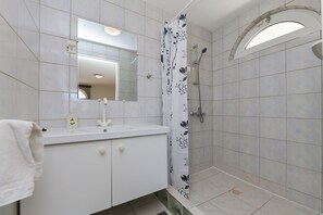 Chuveiro, secador de cabelo, toalhas de banho, papel higiênico