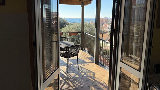 A balcony with a view of the sea and buildings. - The Piano Apartment (Imperia)