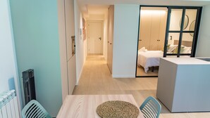 Quarto de hotel compacto com área de refeições, cozinha compacta e área de dormir separada.
