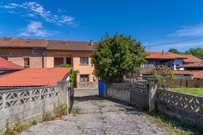 A residential street with houses, a tree, and a gate. - Beautiful Rural House in Nava (Nava)