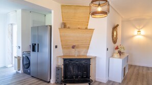 Een moderne keuken met een ingebouwde wasmachine, een zwart fornuis en een houten accentmuur.