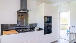 Een moderne keuken met een gasfornuis, oven en een ingebouwde magnetron.