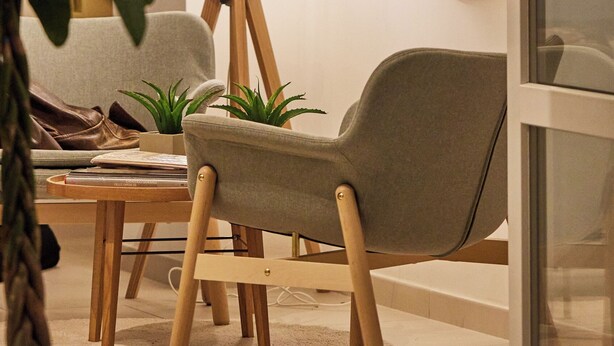 A modern living room with a grey armchair, a wooden coffee table, a potted plant, and a floor lamp. - Villa Vera (Salerno)