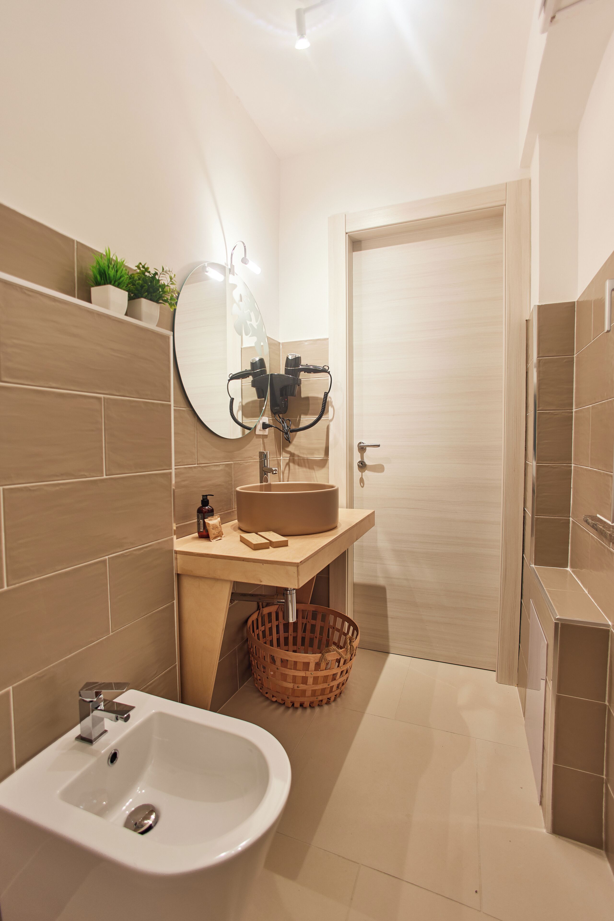 A modern bathroom with a sink, mirror, and shower area.