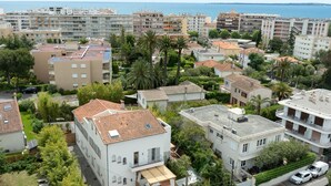A residential area with multi-story buildings, some with balconies, and a view of the sea in the background. - Furnished Studio La Jungle Suite, Mandara Beach (Antibes)