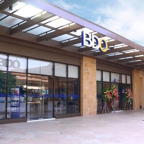 A BDO bank with a modern facade, large glass windows, and a covered entrance area. - Chelsea Tower 2 (Muntinlupa)
