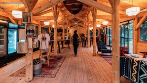 Un intérieur spacieux en bois, avec de hauts plafonds, de grandes fenêtres et une allée centrale.