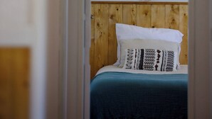 A room with a bed, a macrame wall hanging, and a wooden headboard. - Casa Marmeleiro (Santiago do Cacém)