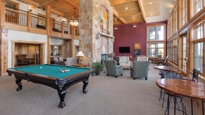 Un espace intérieur vaste et lumineux, doté d’une table de billard, de sièges confortables et de grandes fenêtres.