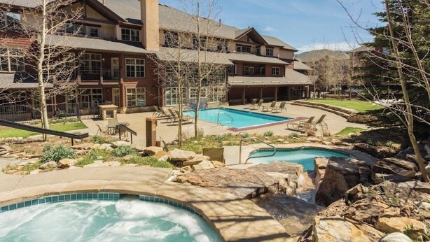 Un complexe hôtelier doté d’une grande piscine, d’un jacuzzi et d’une terrasse couverte.