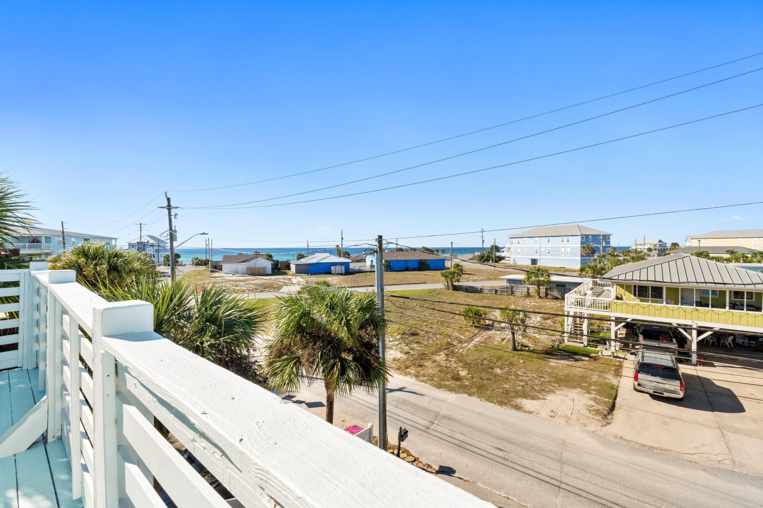 A coastal area with buildings, a road, and a parked car.