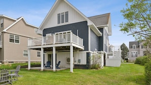 A two-story house with a balcony, a covered porch, and a well-maintained lawn.