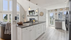 A spacious kitchen with a large island, white cabinetry, and a built-in oven.