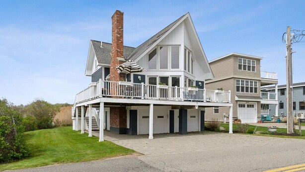 A two-story house with a balcony, a chimney, and a garage. - Coastal Dream Vacation Home at Moody Beach - Sleeps 8 (Wells)