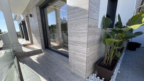 A modern building with a glass entrance, tiled flooring, and potted plants. - Luxury Home in Granada with Private Pool (AN)