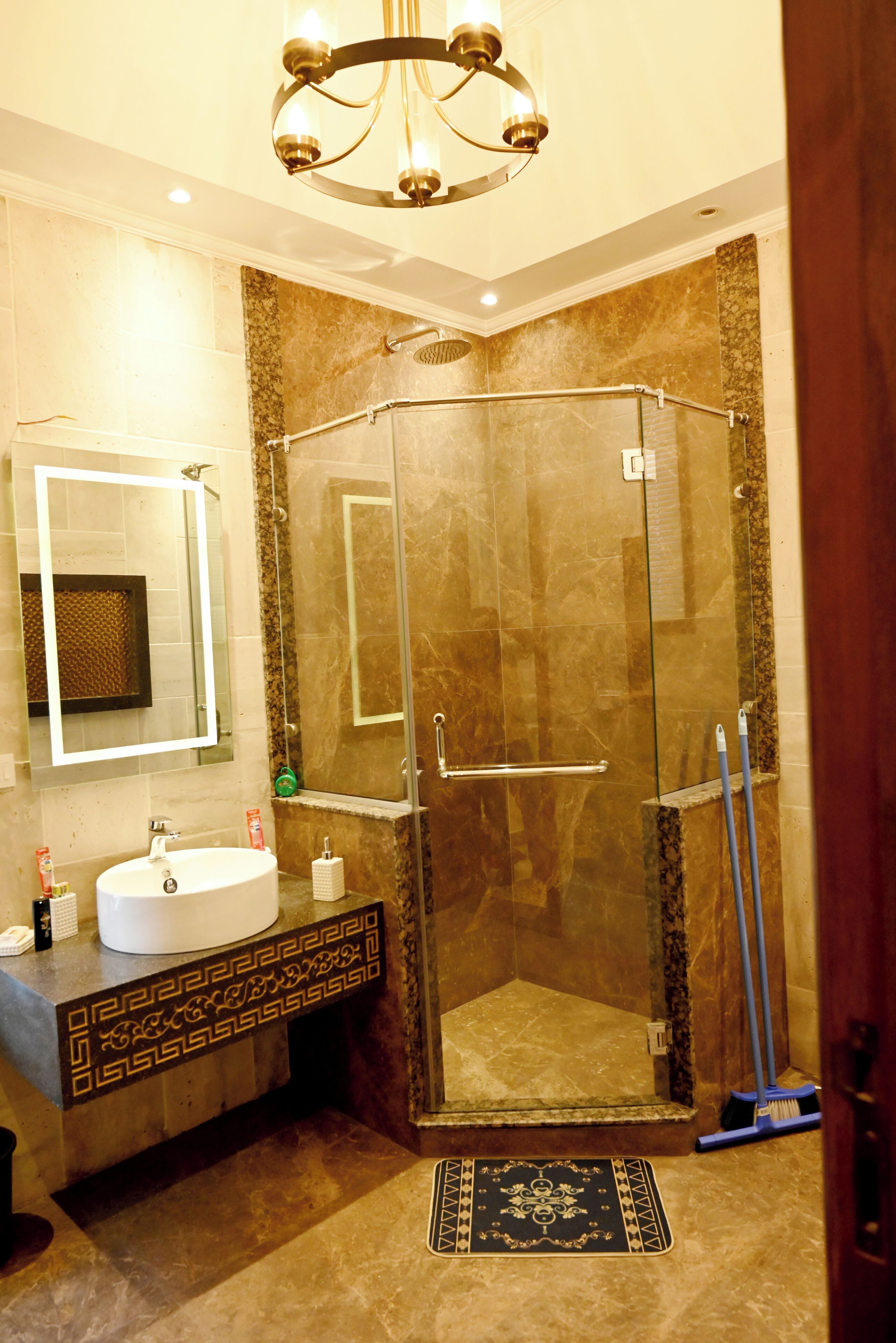 A modern bathroom with a glass-enclosed shower, a vanity with a sink, and a mirror.