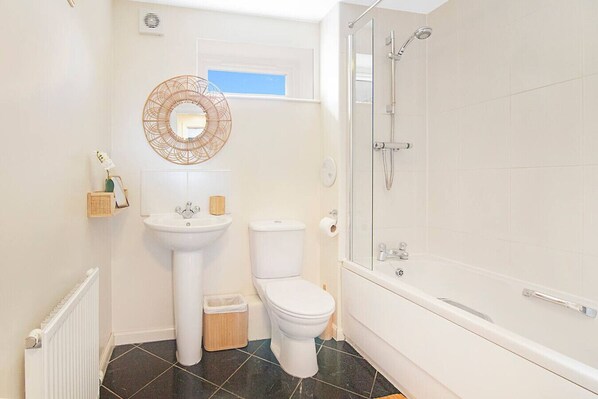 A bathroom with a pedestal sink, toilet, and a walk-in shower.