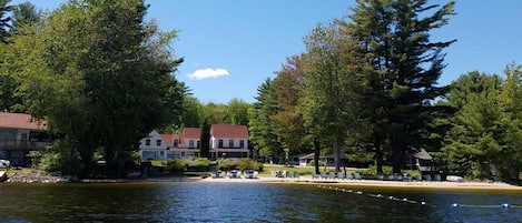 Una propietat al costat d'un llac amb diversos edificis, mobiliari exterior i un moll.