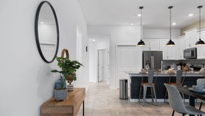 A modern kitchen with white cabinets, a central island, and pendant lighting. - Condo 2bed 2bath Next to Disney w Free Water Park (Davenport)