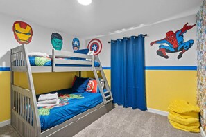 A bunk bed room with superhero-themed wall art, a ladder, and a yellow bean bag. - Gorgeous 5bed TH Close to Disney Water Park (Davenport)