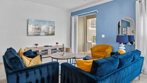 A modern living room with a blue sofa, yellow cushions, a round coffee table, and a yellow armchair. - Gorgeous 5bed TH Close to Disney Water Park (Davenport)