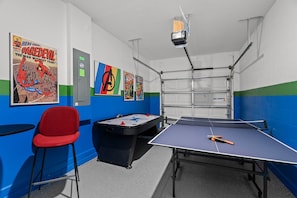 A room with a ping pong table, a pool table, and a projector mounted on the ceiling. - Fully Themed 6bed Fantasy Escape Near Disney (Kissimmee)