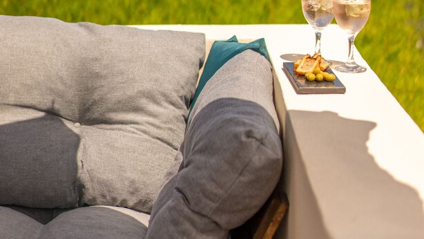 Een terras met een tafel, twee glaasjes water en een bord eten.