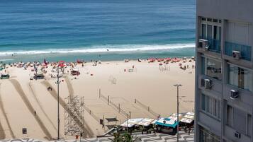 A beach with a road leading to a building.