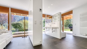 Een moderne slaapkamer met een groot bed, een inbouwkleerkast en een badkamer met een grote spiegel en wastafel.