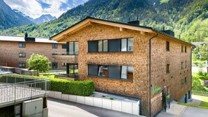 Un bâtiment moderne à deux étages, doté d’une façade en briques, de grandes fenêtres et d’un balcon.