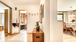 A hallway with a wooden bench, a vase with flowers, and a wall-mounted coat rack. - Appartement Schruns - M Ser-apartments (Tschagguns)