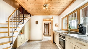 A modern kitchen with wooden cabinets, a granite countertop, and a built-in oven. - Waldh tte Panorama Tschengla (Buerserberg)