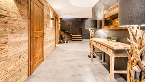 A modern interior with a wooden wall, a staircase, a desk, and a lamp. - Chalet GM - Penthaus (Brand)