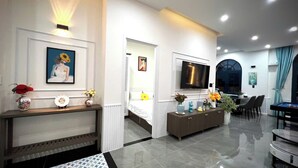 A modern living room with a TV, a sofa, a dining area, and a pool table. - Deluxe 4 br Lucky Villa-Nova Phan Thiet (Tien Thanh)