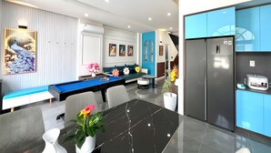 A modern living room with a pool table, a sofa, and a dining table. - Deluxe 4 br Lucky Villa-Nova Phan Thiet (Tien Thanh)