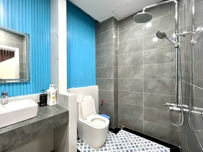 Ein modernes Badezimmer mit einem weißen Waschbecken, blauer Wand und einer Duschkabine.