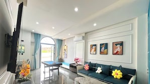 A modern living room with a sofa, coffee table, and a pool table. - Deluxe 4 br Lucky Villa-Nova Phan Thiet (Tien Thanh)