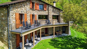 A stone house with a balcony, wooden shutters, and outdoor seating. - LA MASIA DEL TAULAT CHAMBRES D  HOTES (Llo)