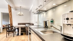 A modern kitchen with a large island, stainless steel appliances, and a built-in oven. - Ferienwohnung Zentral mit Panorama-sonnenterrasse (Brand)