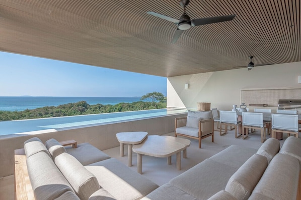 Relax in a comfortable outdoor space with ocean views, a sofa set, dining table, and chairs.