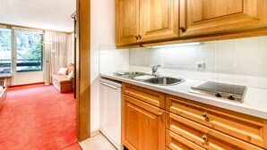 Una cocina moderna con armarios de madera, un lavamanos de acero inoxidable y un horno empotrado.