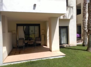 A modern building with a covered outdoor seating area, a small table, and chairs. - 2 Bed Apt-easy Access to Pool-mar Menor Nearby (San Javier)