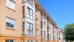 A multi-story residential building with a brick facade, large windows, and a balcony on the upper floors. - Bannermill Place Apartment | Grampian Lettings Ltd (Aberdeen)