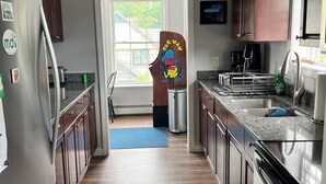 A modern kitchen with wooden cabinets, stainless steel appliances, and a view to the outside. - Charming 2-bedroom apartment with WiFi, AC in downtown Bar Harbor (Bar Harbor)