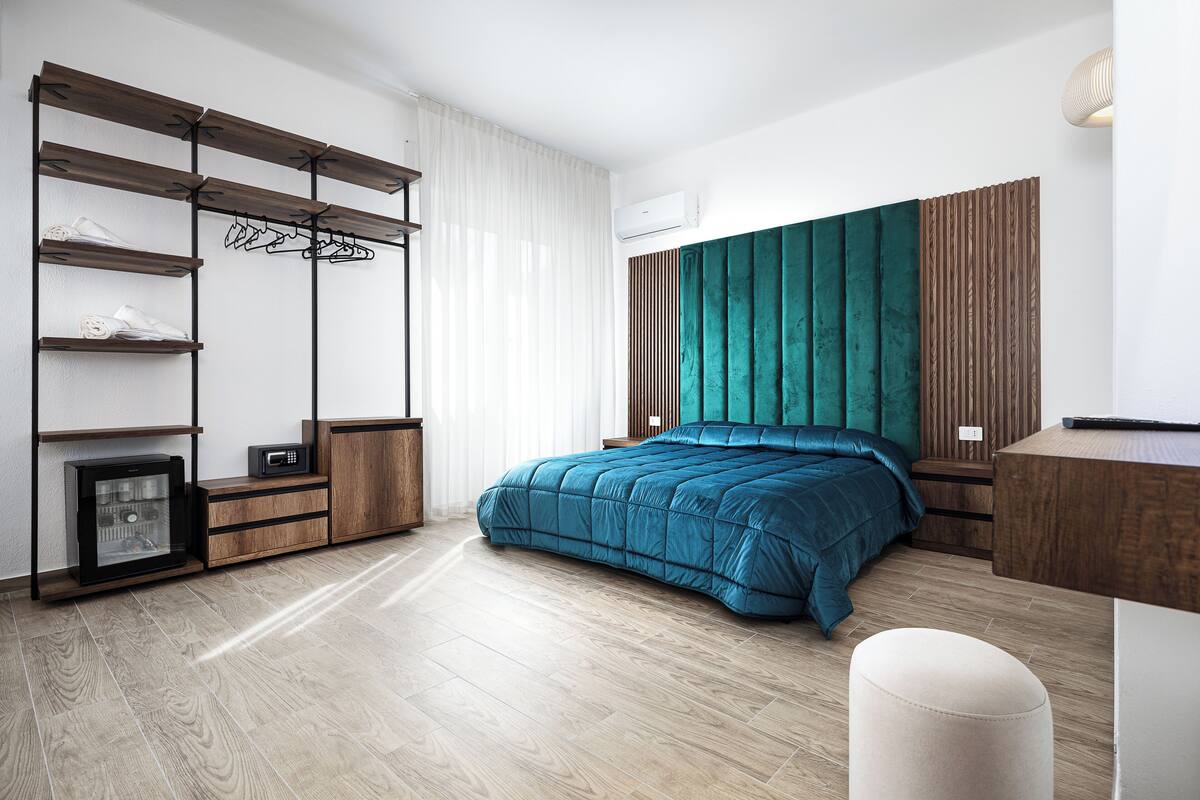 Une chambre moderne comprenant un lit, des étagères intégrées, un bureau et une armoire.