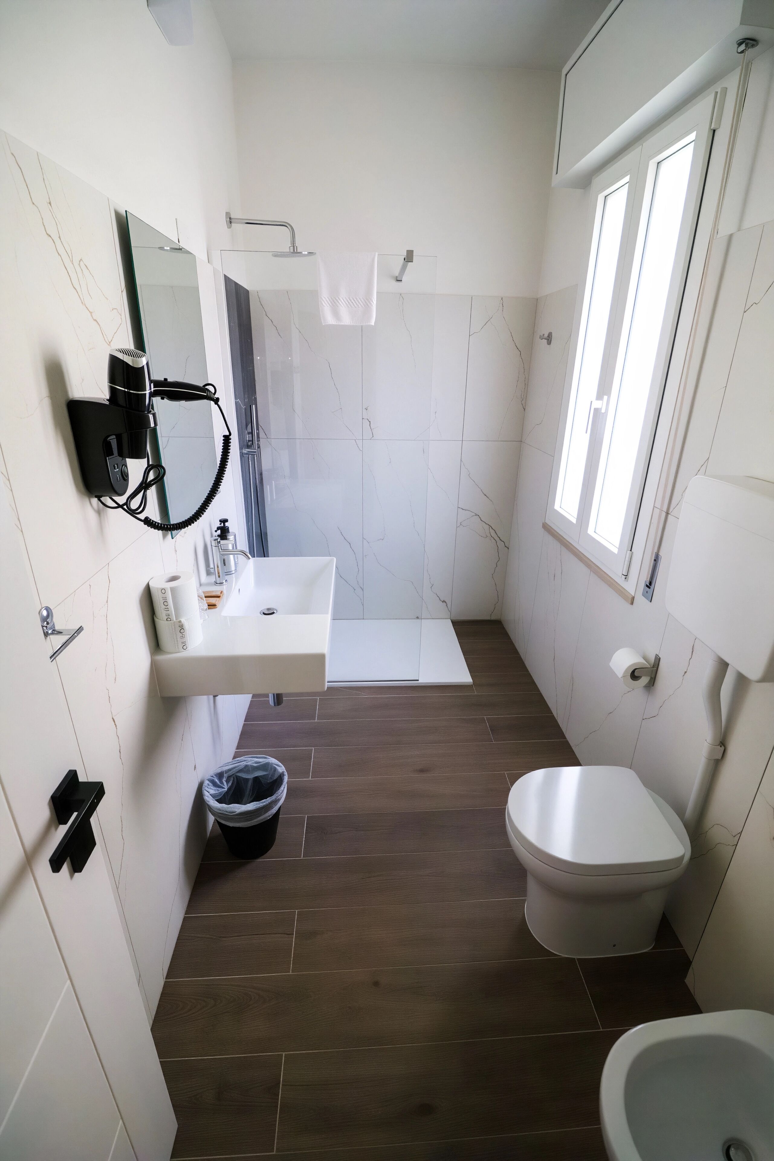 Un baño con lavamanos, inodoro, bidé y zona de ducha.