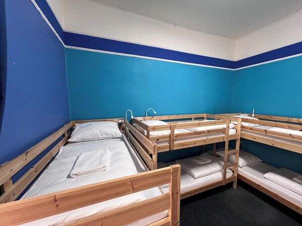 Ein Zimmer mit Etagenbetten, blauen Wänden und einer weißen Decke.